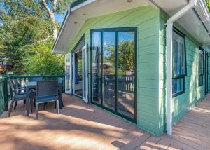a green house with a table and chairs on a deck at Cherry Tree in Belton
