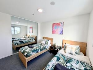 a bedroom with two beds and a mirror at C02-Diamond Loft 2BR apart, elevated living style in Ginninderra