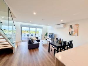 a living room and dining room with a table and chairs at C02-Diamond Loft 2BR apart, elevated living style in Ginninderra