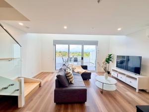 a living room with a couch and a tv at C02-Diamond Loft 2BR apart, elevated living style in Ginninderra