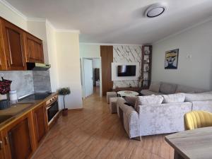 a kitchen and a living room with a couch and a table at Asea Apartaments in Golem