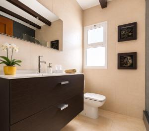 a bathroom with a toilet and a sink and a window at MiVida in San Bartolomé +22 photos
