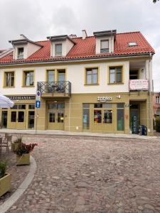 a large yellow building with a red roof at W sercu Rynku in Pasym