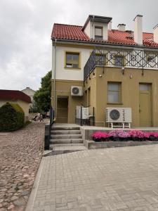 a yellow house with a red roof at W sercu Rynku in Pasym +5 photos