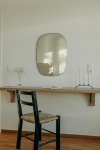 a chair sitting under a table with a mirror at Damma Villa in Kamari