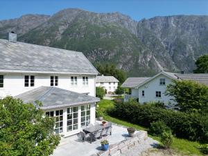 a white house with a picnic table in front of a mountain at Østigård 1810 Prestegårdshuset in Åndalsnes