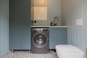 a laundry room with a washing machine and a sink at Østigård 1810 Prestegårdshuset in Åndalsnes
