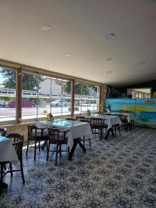 a dining room with tables and chairs and windows at Ada Marin Hotel in Urla