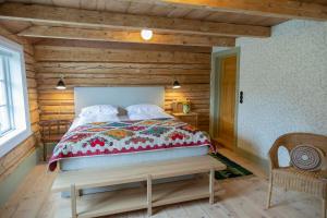 a bedroom with a bed and a wooden wall at Østigård 1810 Prestegårdshuset in Åndalsnes