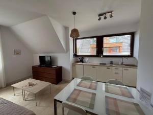 a living room with a table and a kitchen at Bursztynowa 16 Hel in Hel