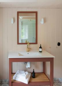 a bathroom with a sink and a mirror at Østigård 1810 Prestegårdshuset in Åndalsnes +42 photos