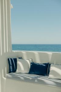 a bench with pillows in a room with a window at Damma Villa in Kamari