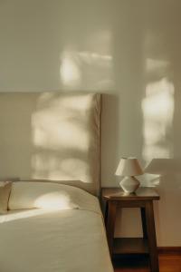 a bedroom with a bed and a table with a lamp at Damma Villa in Kamari