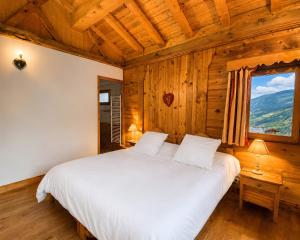 a bedroom with a large bed in a wooden room at Les Dolomites in La Plagne Tarentaise