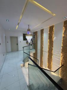 a lobby with a glass staircase and a chandelier at Xclusive Luxury Apt in Mopo Onijebu