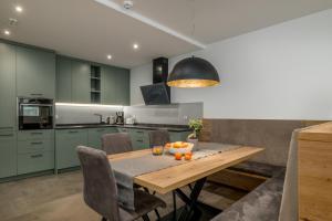 a kitchen with green cabinets and a wooden table with oranges on it at Residence Diana Apartment 402 in Terento