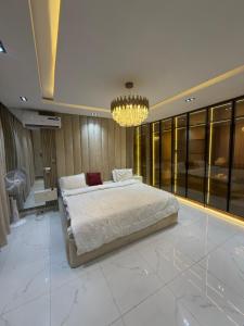 a bedroom with a large bed and a chandelier at Xclusive Luxury Apt in Mopo Onijebu