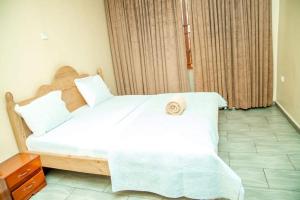 a bedroom with a large white bed in a room at Royce's Apartment in Kigali +7 photos