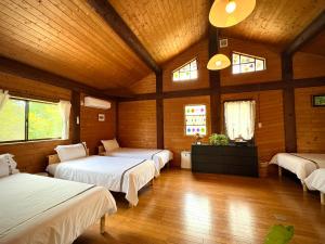 a bedroom with three beds in a room with wooden walls at beau lac biwako in Takashima