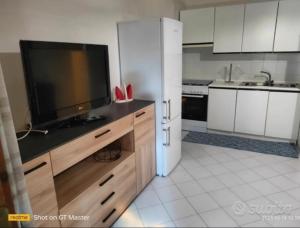 a kitchen with a flat screen tv on a counter at Villa Clelia in Stintino