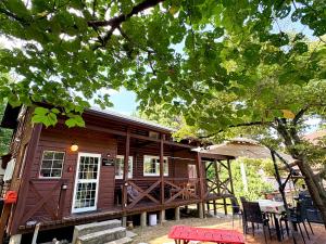 a cabin with a deck and a table and chairs at beau lac biwako annex in Takashima