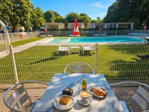 a table with food on it next to a swimming pool at Camping Serenissima in Malcontenta