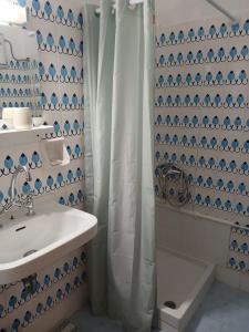 a bathroom with a shower curtain and a sink at Pension Alkistis in Tolo