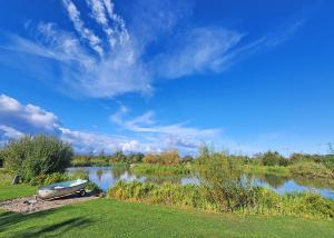 a boat sitting on the grass next to a lake at Monarch Lakes in Boston