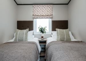 two beds sitting in a room with a window at Monarch Lakes in Boston