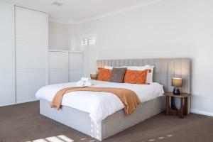 a bedroom with a large bed with orange pillows at Family Friendly, Stylish Floreat, Pool in Perth