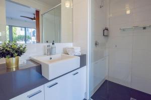 a white bathroom with a sink and a shower at Family Friendly, Stylish Floreat, Pool in Perth