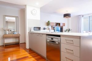 a kitchen with a sink and a dishwasher at Family Friendly, Stylish Floreat, Pool in Perth +16 photos
