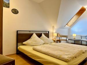 a bedroom with a large bed with yellow sheets and pillows at Ferienhof Weber Nieratz in Wangen im Allgäu