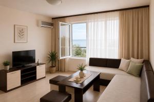 a living room with a couch and a tv at Hotel Topalovi in Nesebar