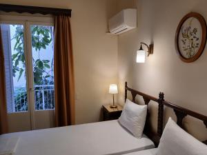 a bedroom with a large bed and a window at Pension Alkistis in Tolo +16 photos