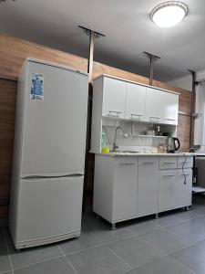 a kitchen with white cabinets and a refrigerator at River guest house in Osh