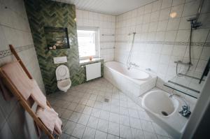 a bathroom with a sink and a tub and a toilet at Natuurhuisje 'n Snuffelstee in Markelo +9 photos