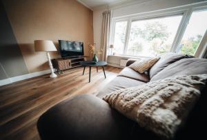 a living room with a couch and a large window at Natuurhuisje 'n Snuffelstee in Markelo