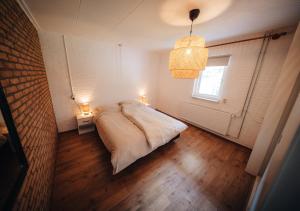 a bedroom with a bed and a window and two lights at Natuurhuisje 'n Snuffelstee in Markelo