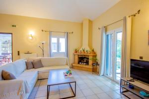 a living room with a white couch and a fireplace at Paxos Santa Marina Villas in Gaios