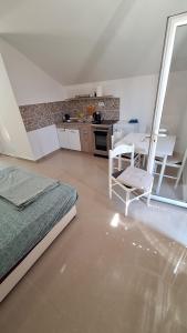 a bedroom with a bed and a table and a kitchen at Coco free parking in Pržno +8 photos
