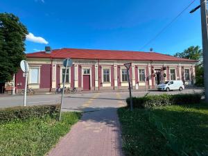 a red and white building with a car in front of it at V8-Kelemen Panzió in Makó