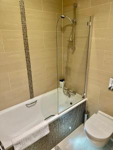 a bathroom with a shower and a toilet and a tub at Russell Square Beautiful Quality Apartment in London