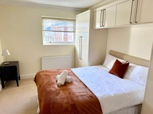 a teddy bear sitting on a bed in a bedroom at Russell Square Beautiful Quality Apartment in London