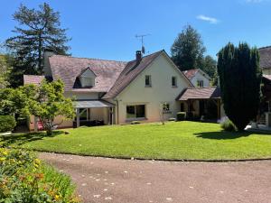 a large white house with a large yard at Le charme d'othe in Bellechaume
