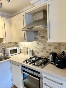 a kitchen with a stove and a microwave at Russell Square Beautiful Quality Apartment in London +34 photos