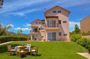 a house with a table and chairs on a lawn at Maison de la mer in Témeni