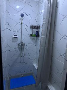 a bathroom with a shower with a white tiled wall at River guest house in Osh