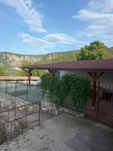 a building with a fence next to a body of water at Casa Elvina in Dubova