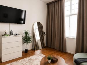 a living room with a tv and a mirror at Schängel Chic 16 in Koblenz